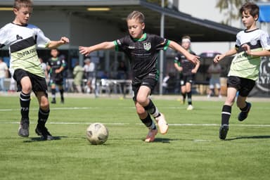 Mastery Matches academy league – player in Mastery kit dribbling through opponents at Adelaide competition